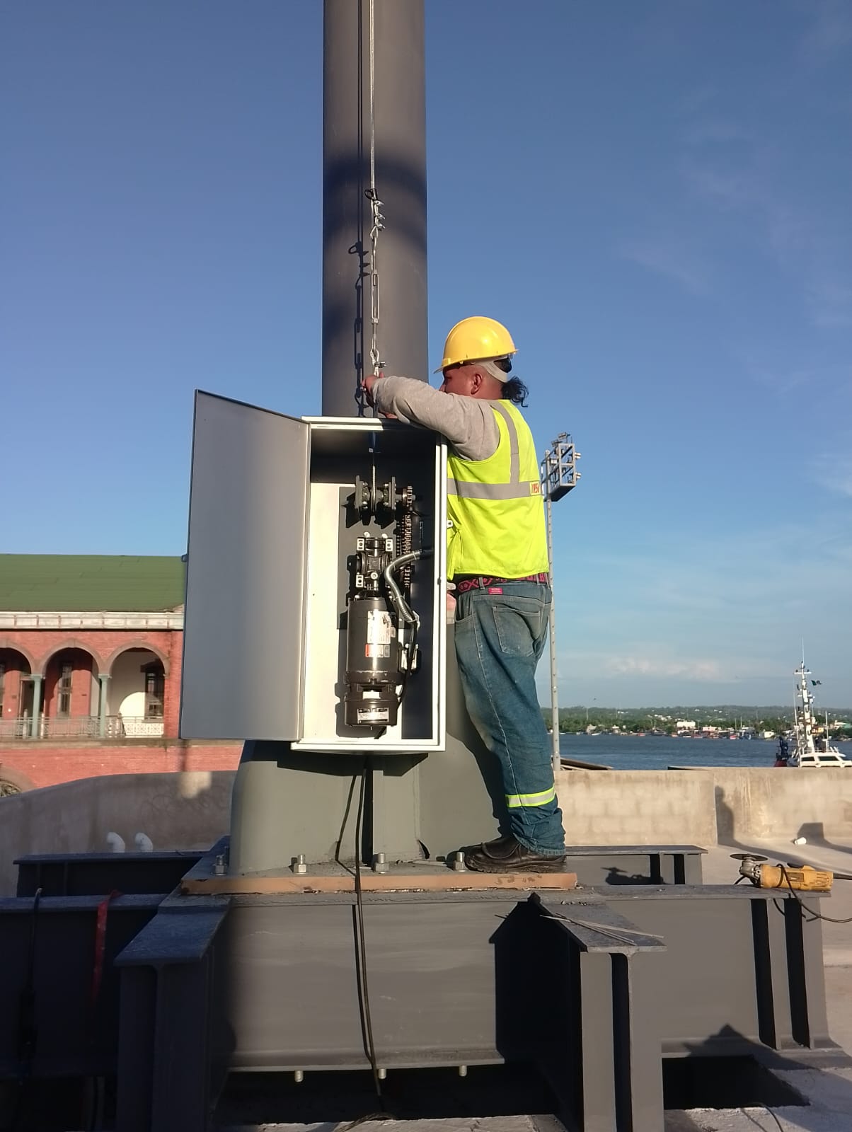 Técnico revisando el mecanismo interior de un asta monumental
